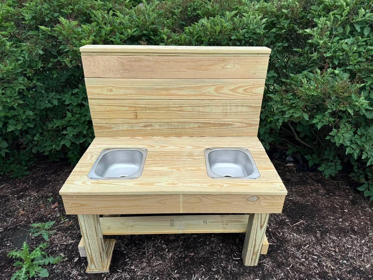 Custom outdoor mud kitchen with steel sinks